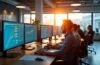 Ein hell erleuchtetes, modernes Büro mit einem engagierten IT-Team, das konzentriert vor großen, transparenten Bildschirmen mit farbigen Datenvisualisierungen und Echtzeit-Performance-Dashboards sitzt, umgeben von natürlichem Tageslicht, das eine warme, freundliche Arbeitsatmosphäre schafft.
