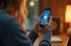 Ein hell erleuchteter, moderner Arbeitsplatz mit einem Android-Smartphone in der Hand einer entspannten Person, umgeben von sanftem Tageslicht und warmen Holztönen, das Vertrauen und Sicherheit beim Schutz persönlicher Daten vermittelt.