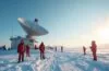 Eine sonnenbeschienene, moderne Forschungsstation in der Antarktis, umgeben von strahlend weißem Eis und tiefblauem Himmel, mit Forschern in warmer Kleidung, die entspannt vor einem hochmodernen Starlink-Satellitenantenne-Setup stehen und dabei freundlich lächeln, während die klare Wintersonne die frostige Landschaft in warmes, goldenes Licht taucht und eine Atmosphäre von Hoffnung, technologischer Verbindung und menschlicher Nähe am Ende der Welt schafft.
