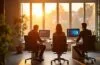 Ein warm erleuchtetes, modernes Entwicklerbüro im Sonnenlicht, in dem konzentrierte Softwareingenieure an hochmodernen Computern sitzen und in lebhafter Kollaboration an innovativen KI-Codierungsprojekten arbeiten – inspirierende Atmosphäre voller Kreativität und Fortschritt.