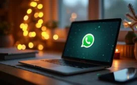 Ein hell erleuchteter Home-Office-Arbeitsplatz in der Vorweihnachtszeit, mit festlichem Schmuck im Hintergrund, auf dem ein moderner Laptop und ein Smartphone offen WhatsApp zeigen – die warme, natürliche Tageslichtstimmung unterstreicht die behutsame, aber ernste Atmosphäre der digitalen Gefahr durch Malware in der festlichen Jahreszeit.