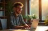 Ein heller, natürlich beleuchteter Arbeitsplatz mit einem lächelnden Entwickler, der konzentriert vor einem modernen Laptop sitzt, umgeben von warmen Holztönen und sanftem Tageslicht, das eine freundliche Atmosphäre von Produktivität und technologischem Fortschritt in der Welt moderner Kotlin-Backend-Entwicklung schafft.