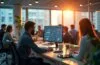 Ein hell erleuchtetes, modernes Büro mit einer Gruppe engagierter Fachleute, die in natürlichem Tageslicht an vernetzten Computern und digitalen Dashboards arbeiten, während die warme Atmosphäre Innovation, strategisches Denken und zukunftsorientierte Zusammenarbeit in der digitalen Infrastruktur symbolisiert.