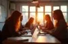 Ein hell erleuchteter, lebhafter Workshopraum mit engagierten Entwickler:innen und Designer:innen unterschiedlicher Herkunft, die bei warmem Tageslicht konzentriert an Laptops und Whiteboards eines gemeinschaftlichen Open-Source-Projekts arbeiten und dabei freundschaftlich miteinander kommunizieren.